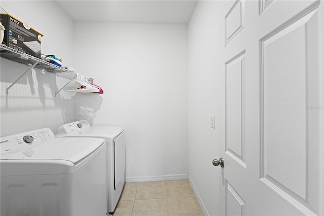 clothes washing area with light tile patterned flooring and washer and dryer