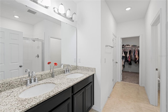 bathroom with tile patterned flooring, vanity, and a shower with door