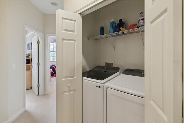 laundry room featuring light carpet and separate washer and dryer