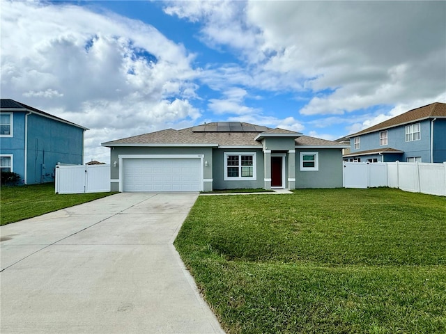 view of front of property with a garage, solar panels, and a front yard