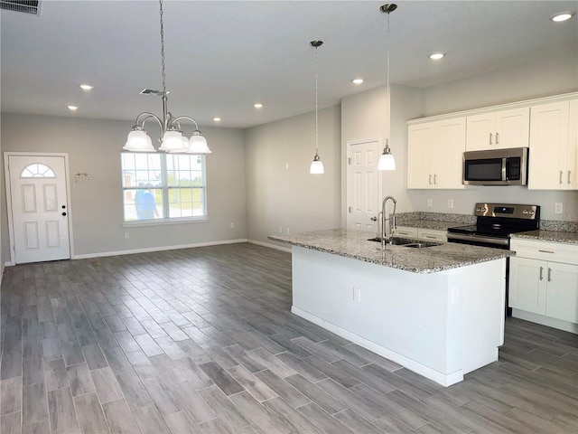 kitchen with stainless steel appliances, white cabinetry, sink, and an island with sink