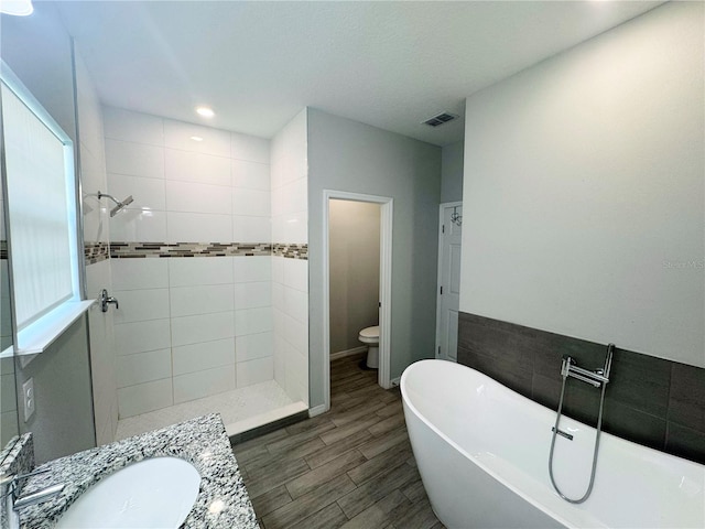 full bathroom featuring independent shower and bath, vanity, toilet, and hardwood / wood-style flooring