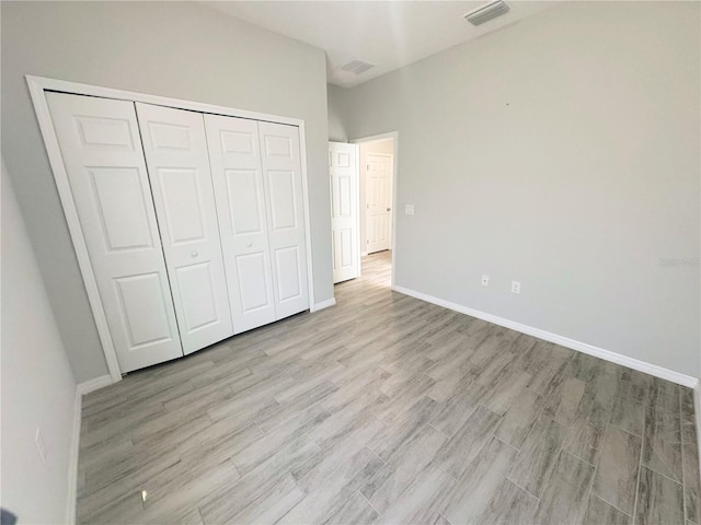 unfurnished bedroom featuring a closet and light hardwood / wood-style flooring