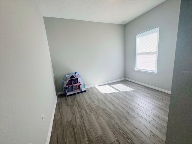 unfurnished room featuring light hardwood / wood-style floors and a textured ceiling