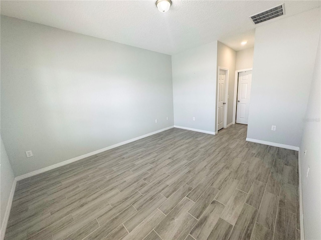 unfurnished room featuring hardwood / wood-style floors and a textured ceiling