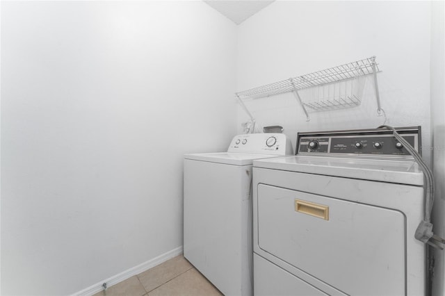 washroom with washing machine and dryer and light tile patterned floors