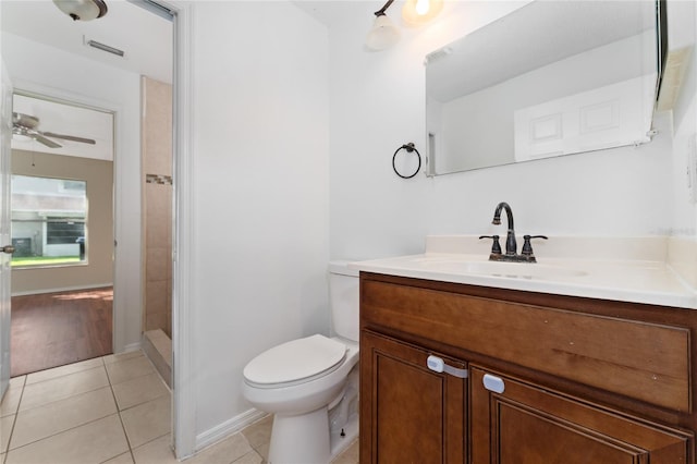 bathroom featuring toilet, ceiling fan, tile patterned floors, walk in shower, and vanity