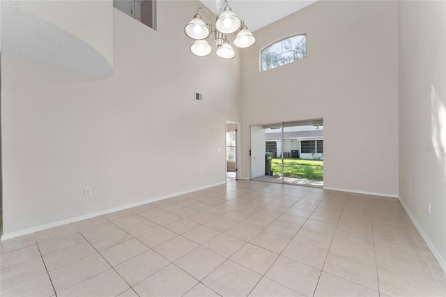 interior space with a towering ceiling, a healthy amount of sunlight, and light tile patterned floors