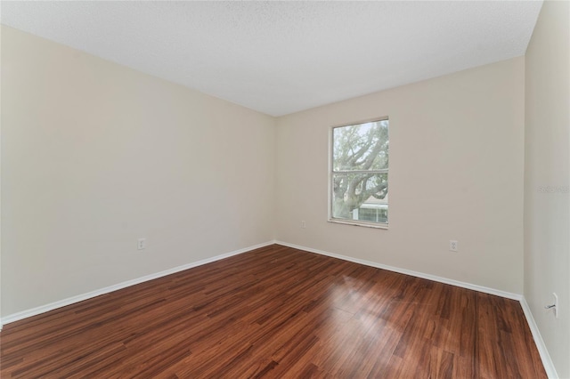 spare room with a textured ceiling and hardwood / wood-style flooring