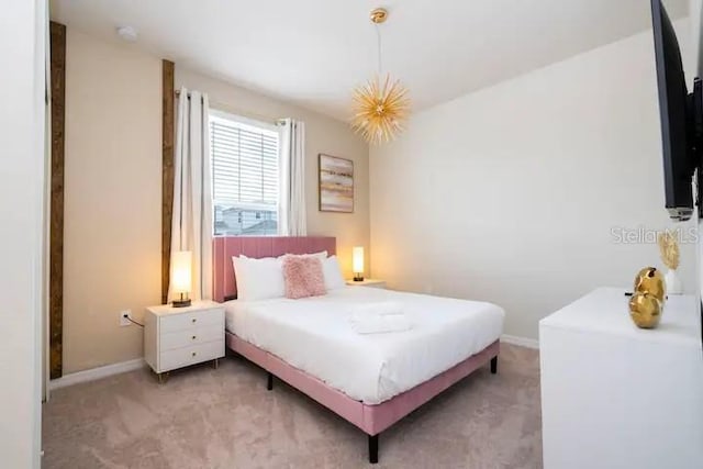 bedroom with light colored carpet and an inviting chandelier