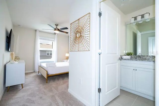 bedroom with ceiling fan, light carpet, and sink