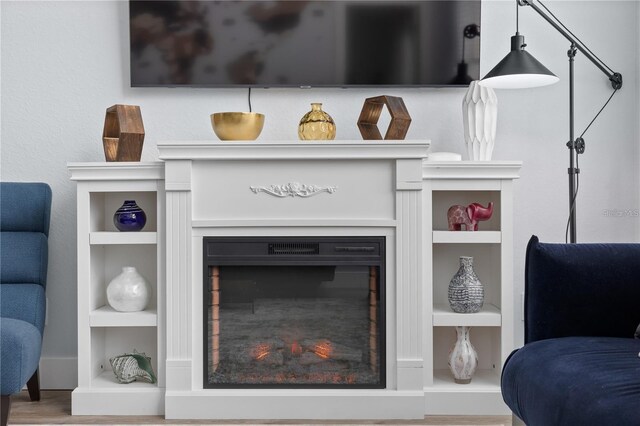 632 Pinewood Dr, Davenport, FL 33896 - detailed view of built in shelves, a warm lit fireplace, and wood finished floors