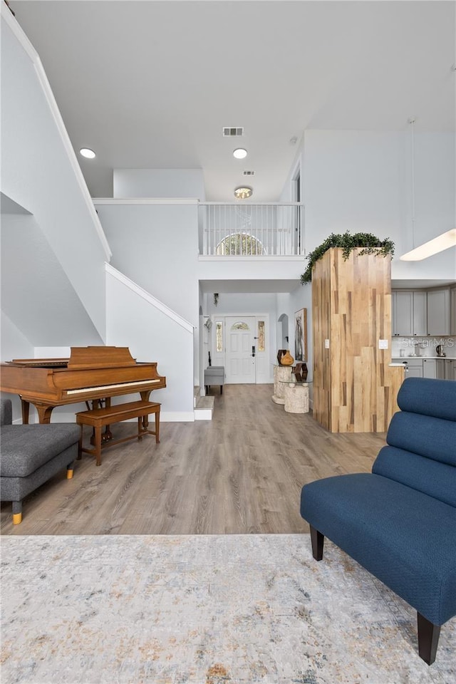 living room featuring a high ceiling and wood-type flooring