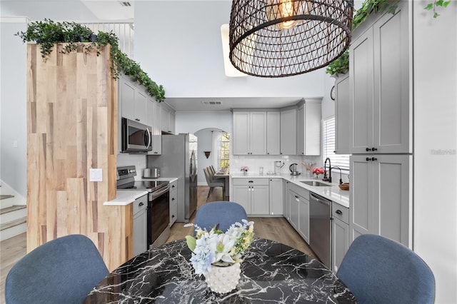 632 Pinewood Dr, Davenport, FL 33896 - kitchen with appliances with stainless steel finishes, a sink, tasteful backsplash, light countertops, and a towering ceiling