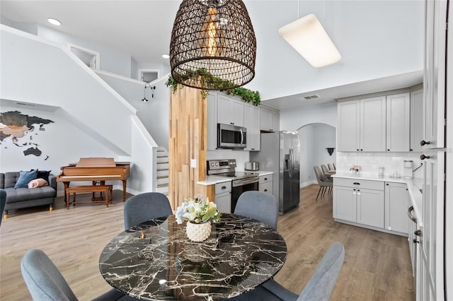 kitchen with light hardwood / wood-style flooring, appliances with stainless steel finishes, and tasteful backsplash