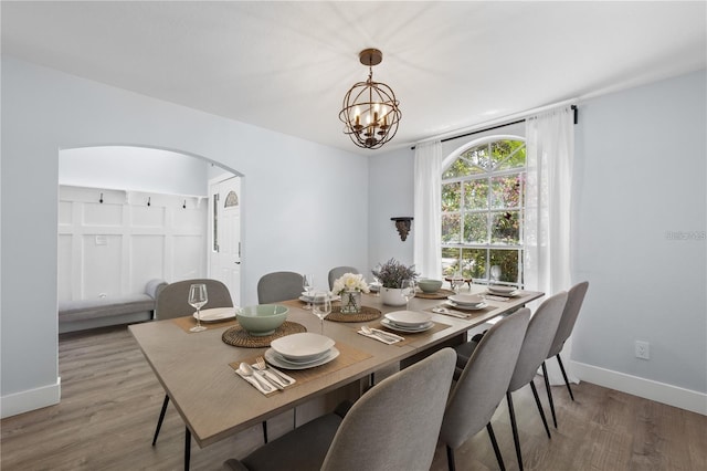 632 Pinewood Dr, Davenport, FL 33896 - dining room featuring arched walkways, wood finished floors, a chandelier, and baseboards