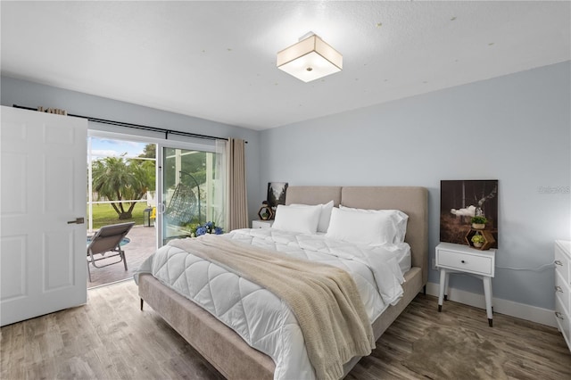 bedroom with wood-type flooring and access to outside