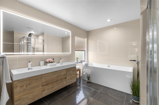 bathroom with tile walls, a bath, and vanity