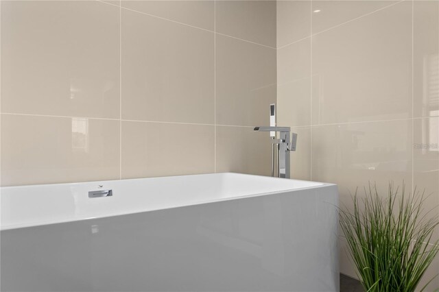 632 Pinewood Dr, Davenport, FL 33896 - full bathroom with tile walls and a freestanding bath