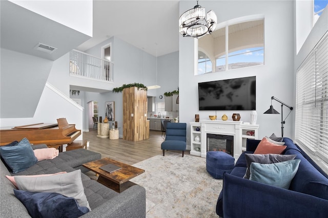 living room with hardwood / wood-style floors, a high ceiling, and an inviting chandelier