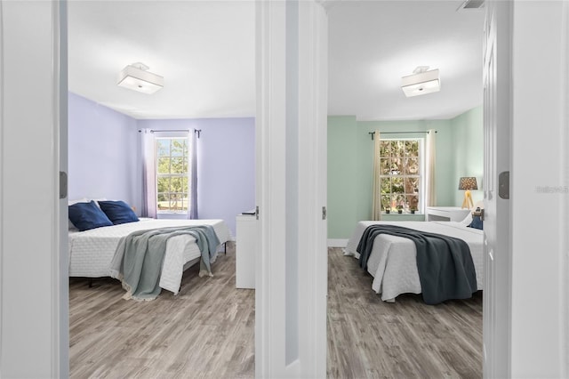 bedroom with light hardwood / wood-style flooring and multiple windows