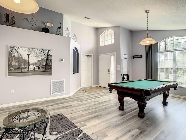 recreation room with a wealth of natural light, light hardwood / wood-style flooring, a textured ceiling, and pool table