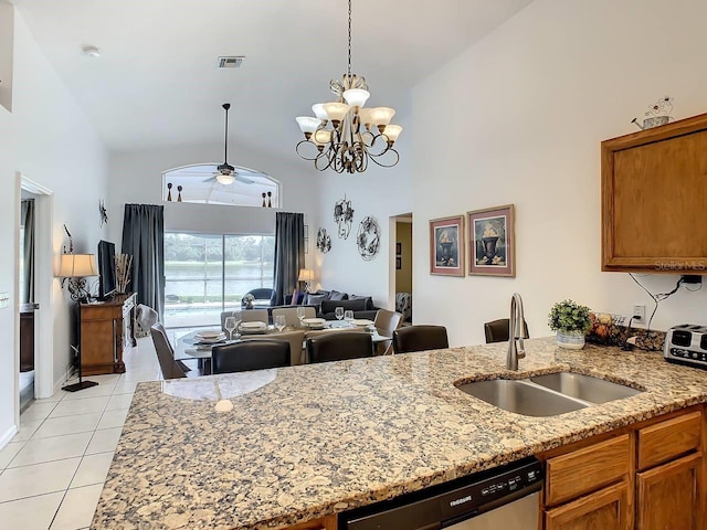 kitchen featuring dishwasher, sink, high vaulted ceiling, and light stone counters