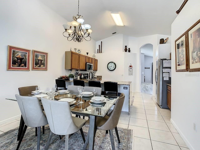 dining space with light tile patterned floors, vaulted ceiling, and a notable chandelier