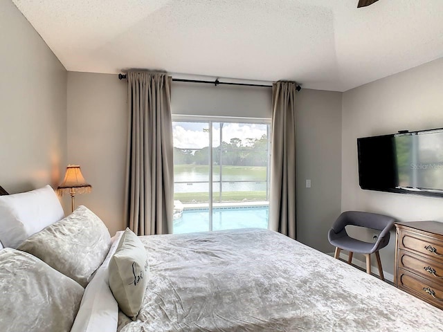 bedroom with ceiling fan, access to exterior, and a textured ceiling