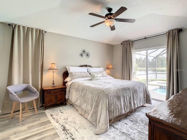 bedroom with ceiling fan, light hardwood / wood-style floors, access to exterior, and a textured ceiling