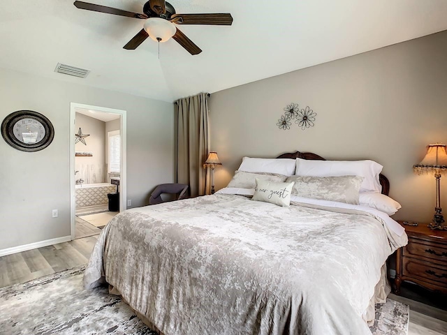 bedroom with light hardwood / wood-style floors, ensuite bath, and ceiling fan