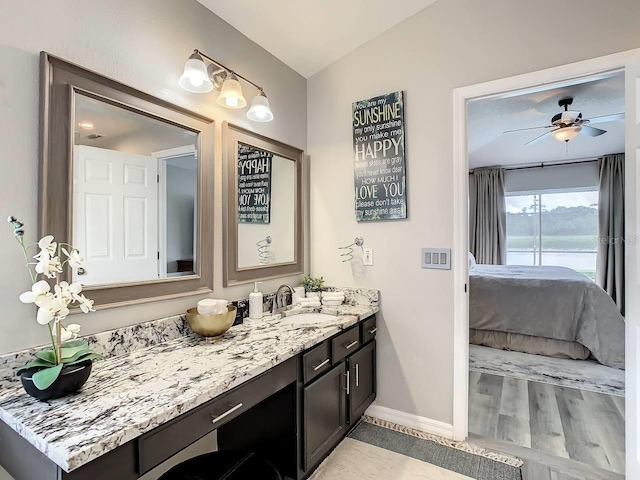 bathroom featuring ceiling fan, hardwood / wood-style floors, vanity, and lofted ceiling