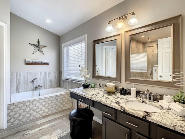 bathroom with vanity, independent shower and bath, and hardwood / wood-style flooring