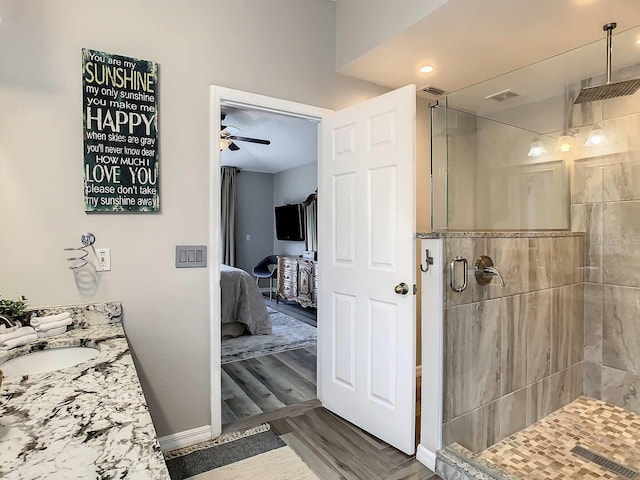 bathroom with ceiling fan, a shower with door, vanity, and hardwood / wood-style flooring