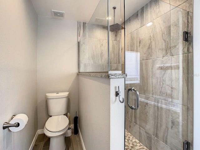 bathroom with toilet, wood-type flooring, and walk in shower