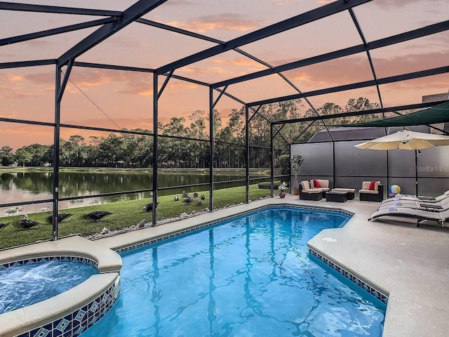 pool at dusk with a lanai, an outdoor living space, an in ground hot tub, a water view, and a patio