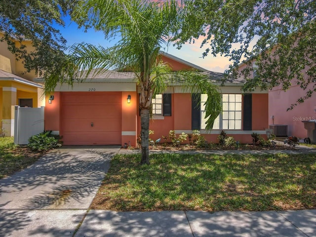 single story home featuring a garage, a yard, and cooling unit