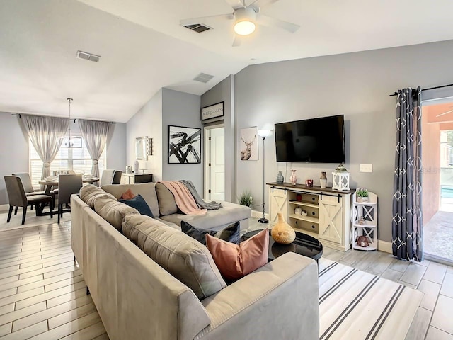 living room with light hardwood / wood-style flooring, lofted ceiling, and ceiling fan