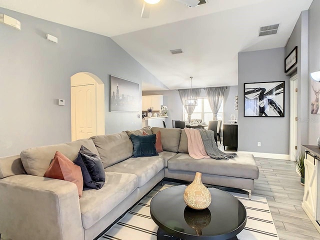 living room featuring light hardwood / wood-style floors, lofted ceiling, and a notable chandelier