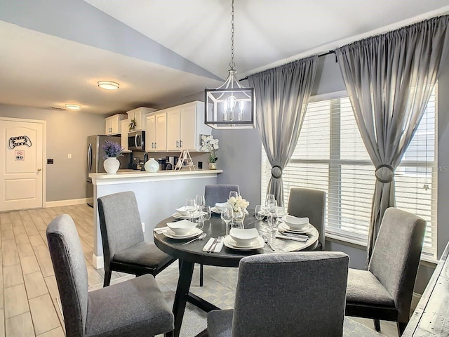 dining area featuring lofted ceiling and a notable chandelier