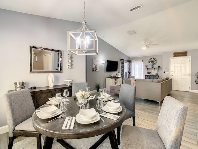 dining area with lofted ceiling, hardwood / wood-style flooring, and an inviting chandelier