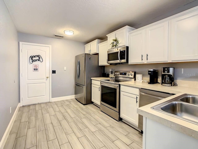 kitchen featuring white cabinetry, stainless steel appliances, light hardwood / wood-style floors, and sink