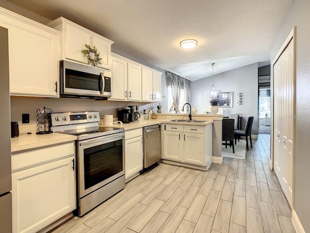 kitchen featuring sink, vaulted ceiling, a healthy amount of sunlight, and stainless steel appliances