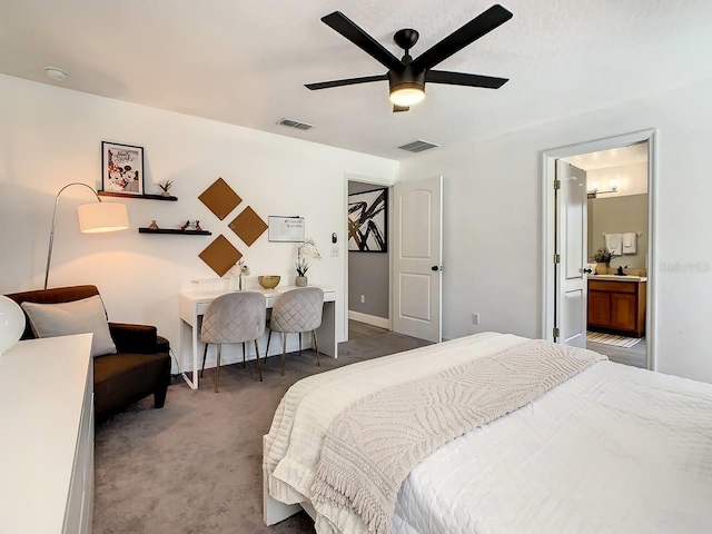 bedroom featuring ensuite bathroom, dark colored carpet, and ceiling fan