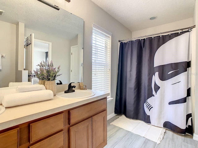 bathroom with a shower with shower curtain, vanity, a textured ceiling, and hardwood / wood-style floors