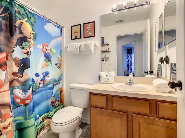 bathroom with toilet, a shower with curtain, vanity, and hardwood / wood-style flooring