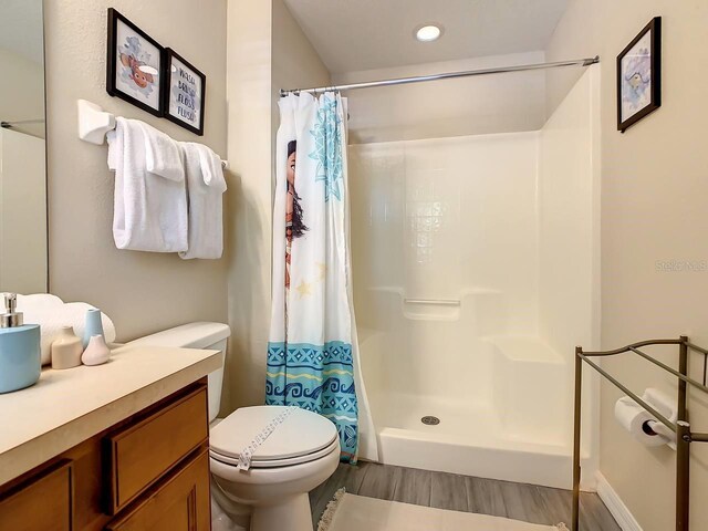 bathroom with walk in shower, vanity, and toilet