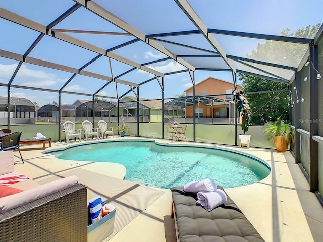 view of pool with glass enclosure and a patio