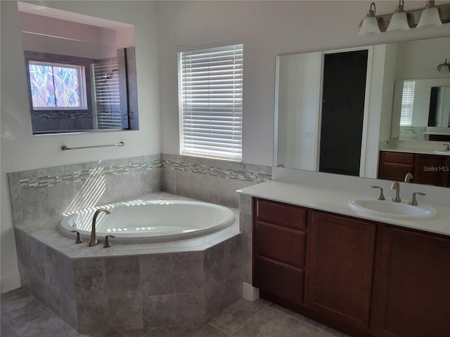 bathroom featuring a relaxing tiled tub, vanity, and tile patterned floors