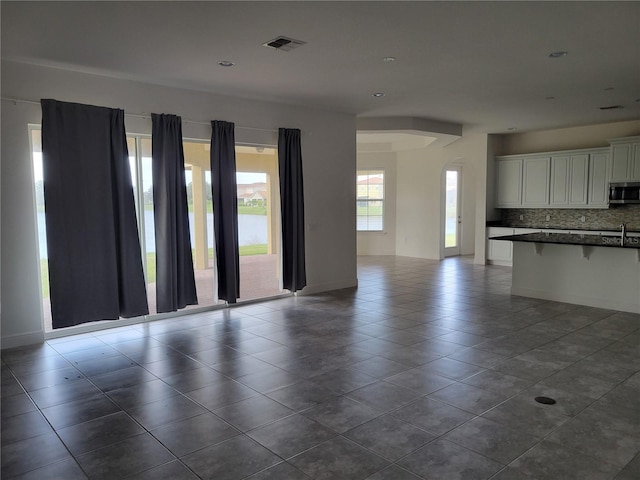 unfurnished living room with sink and dark tile patterned floors